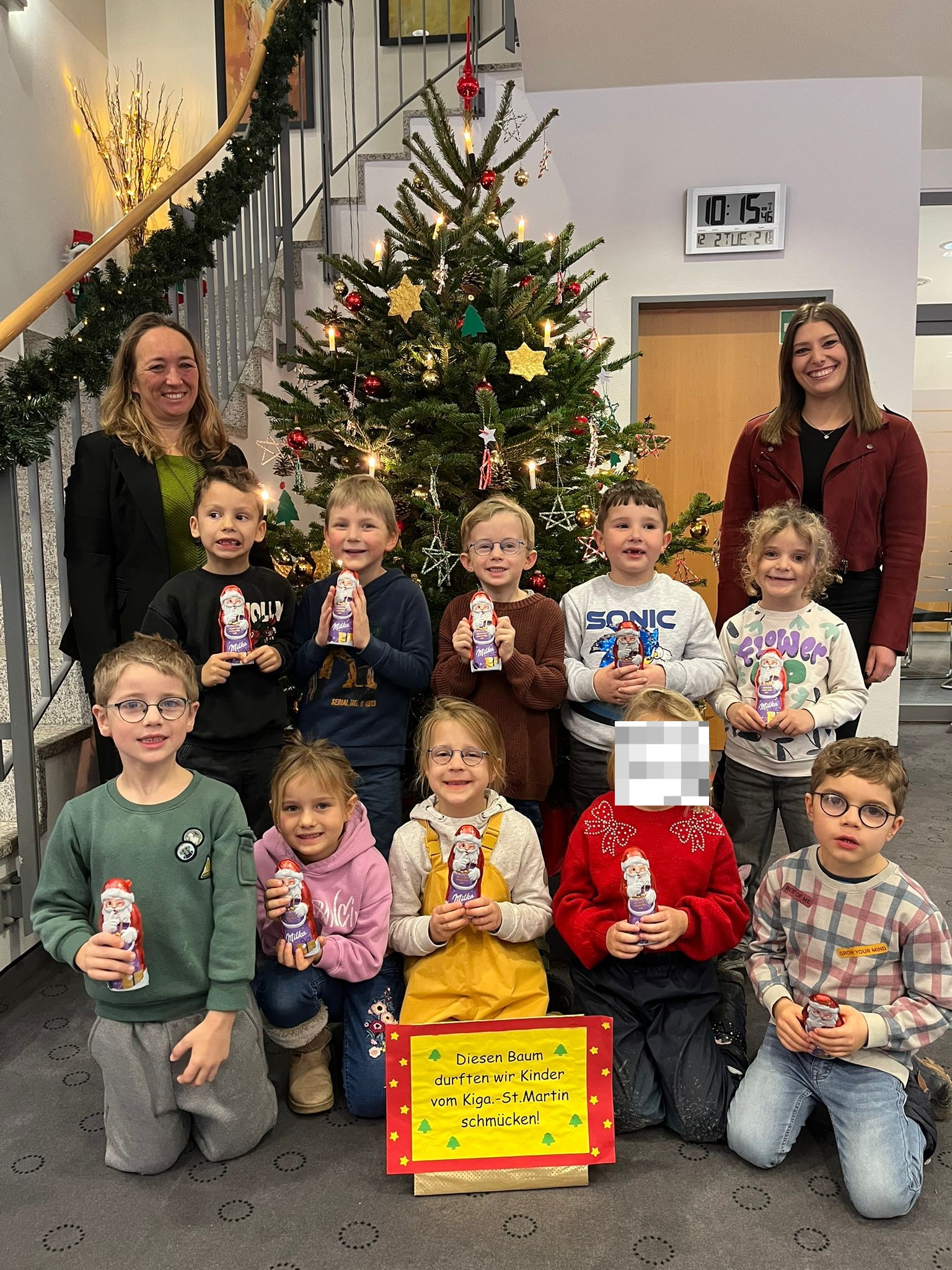 Vorschulkinder schmücken den Christbaum in der Sparkasse