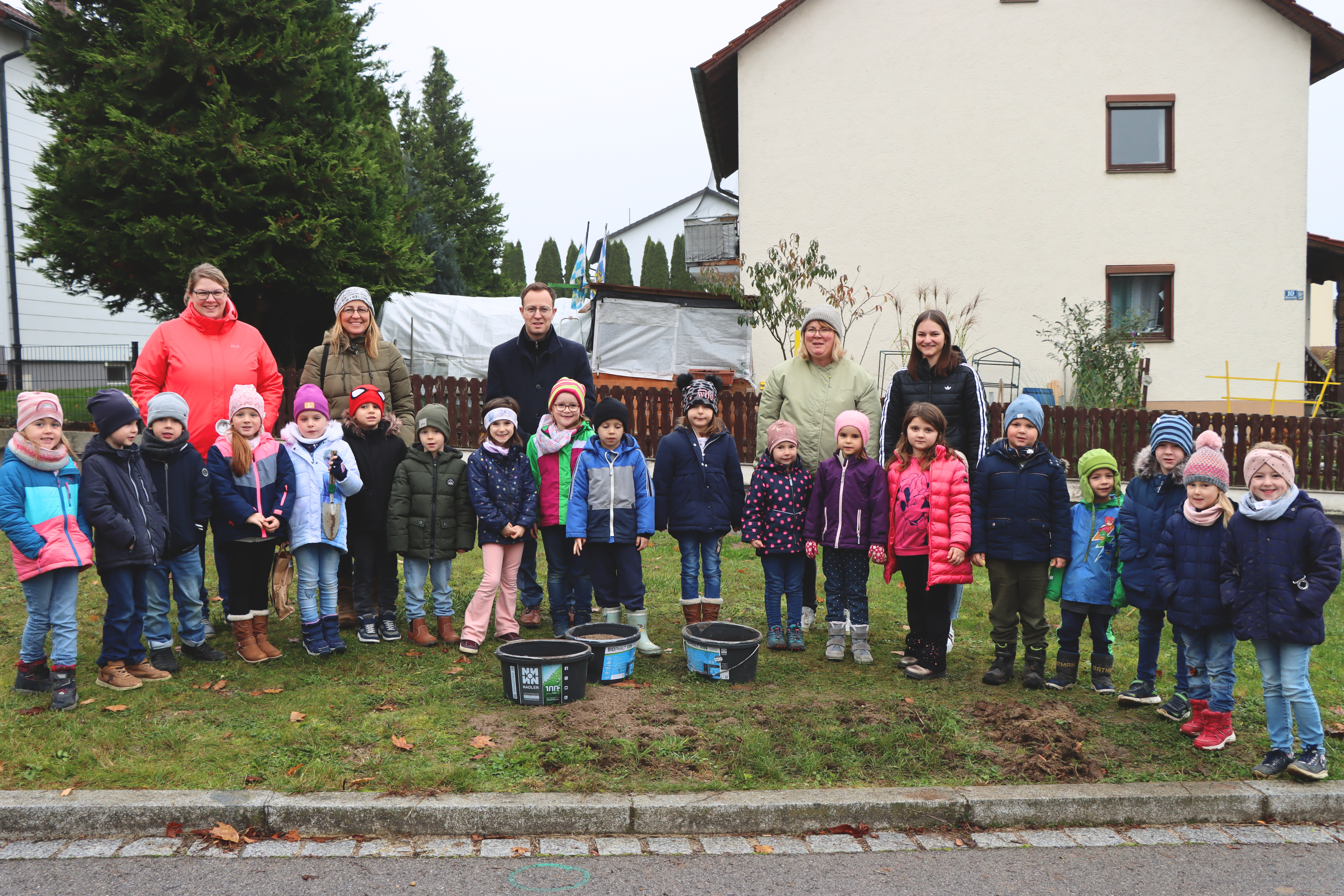 Vorschulkinder stecken Tulpen in der Blumenstraße